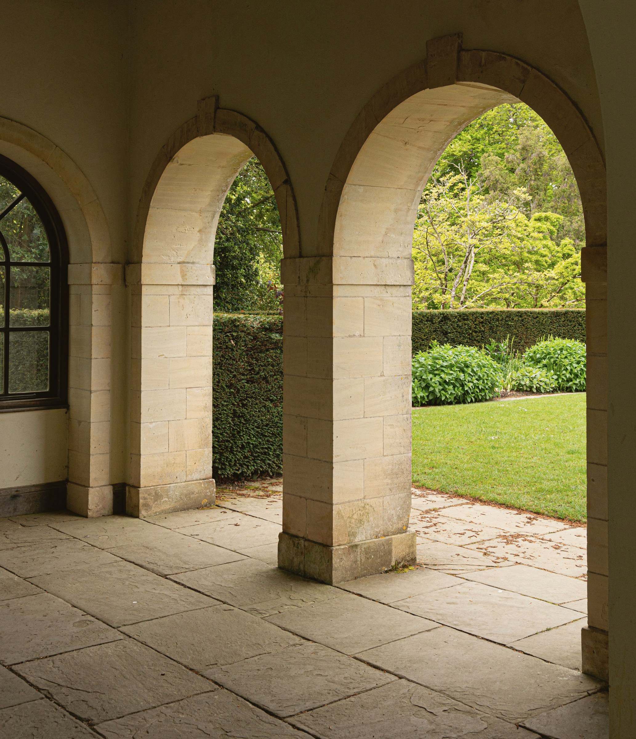 Stone arches of a loggia opening onto a garden