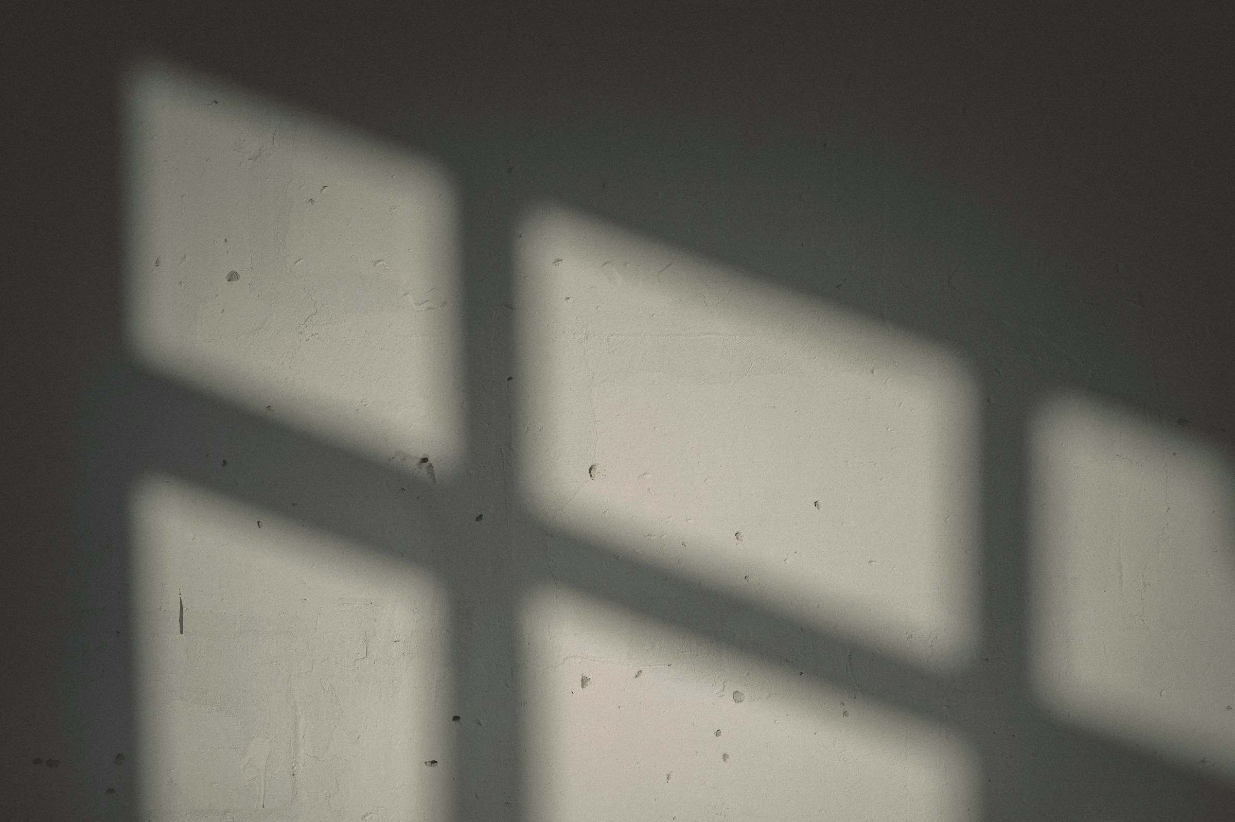 Sunlight projecting a window pattern onto a plaster wall