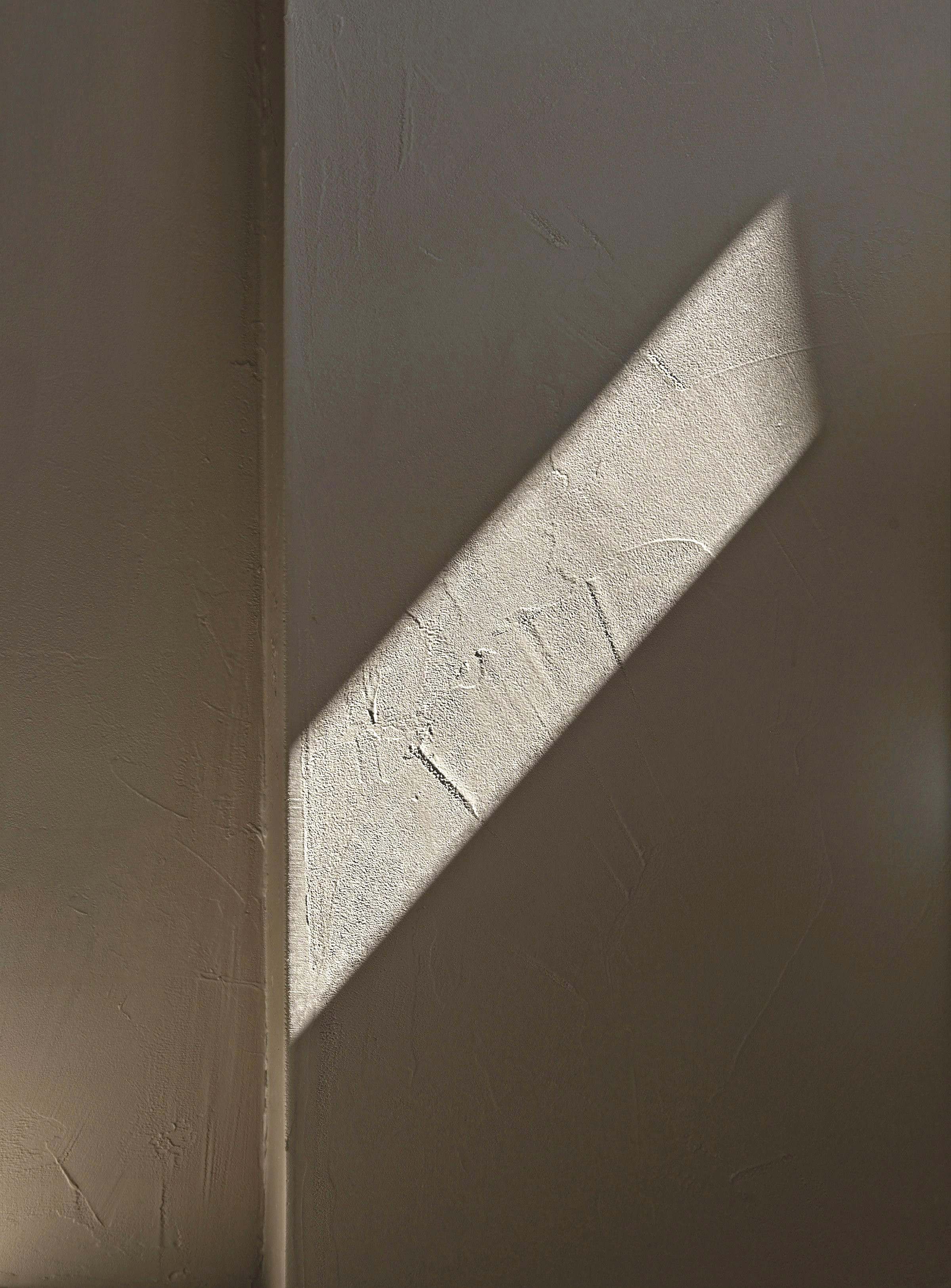 A band of sunlight across a lime plaster wall